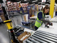 An associate scans a label she just attached to an order heading out at the newly opened Amazon Fulfillment Center in Fall River.   With over 1 million square feet of space, this fulfillment center is the largest in the country.   [ PETER PEREIRA/THE STANDARD-TIMES/SCMG ]