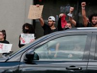 Protesters hold signs at the intersection of Union Street and County in downtown New Bedford before progressing to the site where Malcom Gracia was killed on Cedar Street.  PHOTO PETER PEREIRA