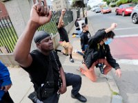 Protestors take a knee in memory of George Floyd at the intersection of Union Street and County Street in downtown New Bedford before marching to the site where Malcom Gracia was killed by police on Cedar Street in 2012.  PHOTO PETER PEREIRA