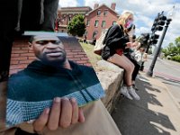 A protestor holds a photo of George Floyd, as he and fellow protestors hold signs at the intersection of Union Street and County Street in downtown New Bedford before marching to the site where Malcom Gracia was killed by police on Cedar Street in 2012.  PHOTO PETER PEREIRA