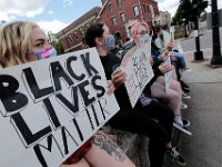 Protesters hold signs at the intersection of Union Street and County in downtown New Bedford before progressing to the site where Malcom Gracia was killed on Cedar Street in 2012.  PHOTO PETER PEREIRA