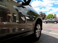 Protesters are reflected off of a vehicle making its way up County Street in New Bedford.  The protest started at the intersection of Union Street and County Street in downtown New Bedford and progressed to the site where Malcom Gracia was killed by police on Cedar Street in 2012.  PHOTO PETER PEREIRA]