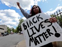 Kayla Gifford and fellow protestors hold signs at the intersection of Union Street and County Street in downtown New Bedford before marching to the site where Malcom Gracia was killed by police on Cedar Street in 2012.  PHOTO PETER PEREIRA