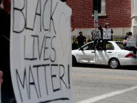 Protesters hold signs at the intersection of Union Street and County in downtown New Bedford before progressing to the site where Malcom Gracia was killed on Cedar Street.  PHOTO PETER PEREIRA