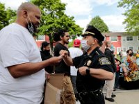 New Bedford police chief Joseph Cordeiro offers his card to a protestor in the hope of opening a line of communication. The protest started at the intersection of Union Street and County Street in downtown New Bedford and progressed to the site where Malcom Gracia was killed by police on Cedar Street in 2012.  PHOTO PETER PEREIRA