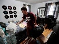 Victor Gonsalves grabs his pillow, a duffle bag and backpack from his room, as he prepares to leave from his home on Harvard Street in New Bedford  for his first year at Harvard University.  PHOTO PETER PEREIRA