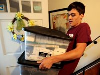 Victor Gonsalves brings bins filled with items he thinks he needs, as he prepares to leave from his home on Harvard Street in New Bedford  for his first year at Harvard University.  PHOTO PETER PEREIRA