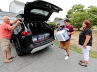 Raul Bourguignon, stepfather, Luis Gonsalves, brother, and Raquel Bourguignon, mother, look on as Victor Gonsalves packs what he is bringing into the back of their SUV, as he prepares to leave from his home on Harvard Street in New Bedford  for his first year at Harvard University.  PHOTO PETER PEREIRA