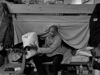 Melvin Parker peeks out from under his bed to collect an arrived package for him at the House of Hope homeless shelter on Mount Pleasant Street in New Bedford.