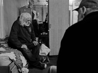 J.P. Fountaine, a recovering heroin addict, speaks with Robert Hughes, program director, while sitting on his bed at the House of Hope homeless shelter on Mount Pleasant Street in New Bedford.