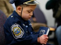 JJ Montalban, 6, who was born with congenial heart defects, looks at the Behind the Badge book given to him before he is sworn in as an honorary New Bedford police officer by police chief, Paul Oliveira at a ceremony held at police headquarters on Rockdale Avenue in New Bedford.  JJ Montalban is currently in need of a heart transplant. PHOTO PETER PEREIRA