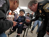 New Bedford Police Chief, Paul Oliveira, grabs JJ Montalban, 6, NBPD badge, as he and officer Shane Harris, left, ask JJ if he is ready to sworn in as an honorary New Bedford police officer at a ceremony held at police headquarters on Rockdale Avenue in New Bedford.  JJ Montalban, who was born with various congenial heart defects, is currently in need of a heart transplant. PHOTO PETER PEREIRA