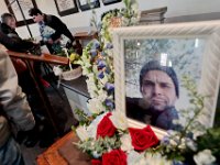 A photo of Mark Cormier Jr. is seen in the foreground as his parents, Richard Marques and Annette Blankenship are seen in the distance during a service in celebration of Mark's life held at the Seamen's Bethel in New Bedford.  Mark Cormier Jr., 35, along with two other fishermen were lost at sea aboard the New Bedford fishing vessel Leonardo on November 24, 2019.     PHOTO PETER PEREIRA