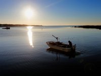 The sun rises in the background as Matt Loo heads out to his 1acre oyster farm at Jack's Cove off of West Island in Fairhaven, MA for an early morning collection.