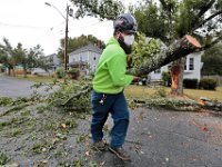 Dwayne Pinkham moves a cut section of a tree that fell due to the high winds across Kenney Street in New Bedford.   PHOTO PETER PEREIRA