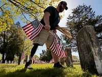 Christopher Gomes, veteran agent for the city of New Bedford, places American flags at the graves of veterans buried at the Pine Grove Cemetery in New Bedford, MA on May 22, 2020, in preparation for Memorial Day.  Mr. Gomes, an Army veteran, lost his right leg when an IED exploded while serving in Iraq in 2008. PHOTO PETER PEREIRA