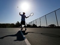 Ed Rose's shadow plays along, as he casts the ball into the air, while serving during a tennis match with friends at Fort Phoenix in Fairhaven on a hot morning.   PHOTO PETER PEREIRA