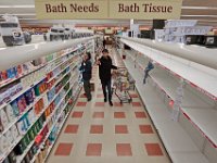 Market Basket grocery clerk, Helena Brosius, helps a customer find soap, while on the other side of the isle, the shelves which normally contain toilet paper and other paper goods are completely empty at Market Basket in New Bedford, MA on March 16, 2020.  PHOTO PETER PEREIRA