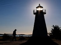 The sun rises behind the Ned's Point lighthouse as a walker makes his way around the iconic Mattapoisett lighthouse.   PHOTO PETER PEREIRA