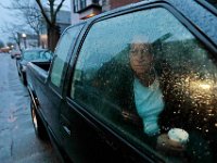 A homeless woman enjoys a cup of coffee inside her boyfriends pickup truck parked in front of the Mercy Meals food pantry in downtown New Bedford, where she picked up coffee and breakfast on a rainy morning.   PHOTO PETER PEREIRA