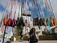 A woman walks past some for custom hand bags for sale hanging from a rack outside of Shara Porter Hand-Printed Accessories on Elm Street in Padanaram village Dartmouth.  PHOTO PETER PEREIRA
