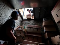 Pat Mooney, above, hands down the daily produce delivery to Justin Ramos down below street level at the No Problemo loading dock on William Street in downtown New Bedford.  PHOTO PETER PEREIRA