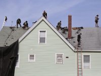 Workmen are seen stripping the existing roof from a three decker residence in the south end of New Bedford, in preparation to install a new roof.  PHOTO PETER PEREIRA