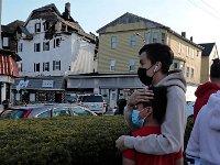 A friend of the family offers Tomas Gomez Jimon, 11 some confort.  His father Tomas Gomes and Juan Macario Mejia died in an early Monday morning fire on Acushnet Avenue in New Bedford.  The wreckage can be seen in the background.