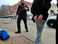 New Bedford police arrest a man for consumption in public in front of the bus station on Pleasant Street downtown as part of an effort by police to clean up a troubled zone.