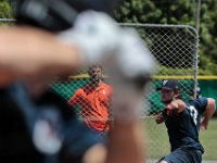 A coach looks on as Miami of Ohio University pitcher, Jonathan Brand, throws during the Wareham Gatemen first practice session in preparation for the upcoming Cape Cod Baseball League season.