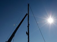 Alan Johnson of Brownell Systems finds himself high above Mattapoisett harbor as he places the strap to remove the mast of a sailboa they are pulling out of the water, as boating season comes to a close.