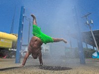 Elijah Garcia, 7, takes shelter from the sweltering heat, by playing at the sprinkler station at Ben Rose Park in New Bedford.