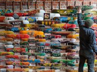 Jay Vasconselos, owner, installs a new deck on the colorful wall of skateboards at Solstice in downtown New Bedford.