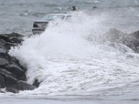 A car making its way across the Gooseberry Island causeway in Westport is covered by a large wave, as a Nor'easter makes its way across the Northeast.