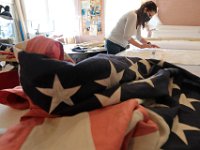 Dianne Veiga of Brewer Banner Designs, draws stars on weathered linen for the twenty four, 34 star United State flags for the Apple TV series: Dickinson at their shop on Forest Street in New Bedford. The flags which they have weathered, will be used during a Civil War scene draped over caskets.