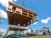 A1 Crane workmen lift an entire house which was built on the ground, to place on the newly finished elevated foundation in Westport, MA on May 12, 2021.