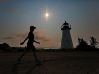 Lisa Hicks goes for a walk around the iconic Ned's Point lighthouse in Mattapoisett, as the sun rises in the distance.