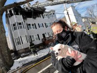Shelley Avila-Martins of the New Bedford Police Animal Control Department, carries a dog she rescued from the fire at a multi-residence on Ashley Boulevard in New Bedford. This is the fifth fire in New Bedford in the last eight days.