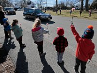 Students of the St. Francis Xavier school in Acushnet line the street in front of their school holding pink carnations to honor Therese Ledoux (the school's kindergarten teacher for thirty years) as her funeral motorcade drives by.  Mrs. Ledoux was 103 years old when she passed away last week, and was a regular presence at the Acushnet school long after she retired.