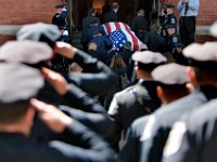 The casket of New Bedford police officer Sgt. Michael Cassidy is brought into Our Lady of Mount Carmel Church for the funeral mass.  Sgt. Cassidy died after a battle with COVID-19.