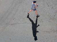 A man has his shadow for company as he walks across N Second Street in downtown New Bedford as seen from the top level of the parking garage.