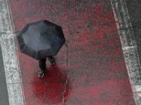 A pedestrian makes his way across the red crosswalk on Elm Street in New Bedford on a rainy morning, as seen from the top of the parking garage.