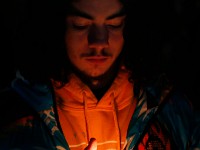 A student protects the light of his candle during a Umass Dartmouth candlelight vigil to honor Frankie Petillo Jr. who died after geing hit by a car, and Alexandra Landra who died unexpectedly in a separate incident.