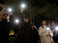 Students and staff hold up the flashlights on their phones during a Umass Dartmouth candlelight vigil honoring Frankie Petillo Jr. who died after geing hit by a car, and Alexandra Landra who died unexpectedly in a separate incident.