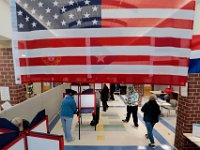 An American flag hangs from the ceiling, as voters cast their votes for the 2020 Presidential election inside of the Normandin Middle School polling station in New Bedford.  [ PETER PEREIRA/THE STANDARD-TIMES/SCMG ]