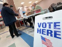 Voters check-in to receive their ballots at the Normandin Middle School polling station in New Bedford.   [ PETER PEREIRA/THE STANDARD-TIMES/SCMG ]