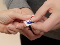 A voter is handed a sticker after casting his vote for the 2020 Presidential election at the Buttonwood Warming House polling station in New Bedford.  [ PETER PEREIRA/THE STANDARD-TIMES/SCMG ]