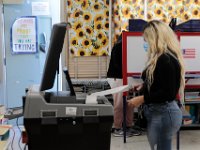 A voter casts her vote in the 2020 Presidential election inside of the Hathaway school polling station in New Bedford.  [ PETER PEREIRA/THE STANDARD-TIMES/SCMG ]