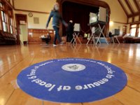 Voters walk past the stickers placed on the ground for social distancing inside of the Fairhaven Town Hall polling station.  [ PETER PEREIRA/THE STANDARD-TIMES/SCMG ]