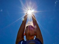 The sun shines through Sydney Lipsett's, 17, hands as she and fellow Global Learning Charter Public School 11th graders perform yoga at Riverside Park on June 16, 2016 as they wind down their school year.